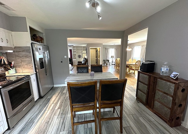 1325 W Chestnut St, Denison, TX 75020 - kitchen with appliances with stainless steel finishes, light wood-style floors, white cabinetry, and light countertops
