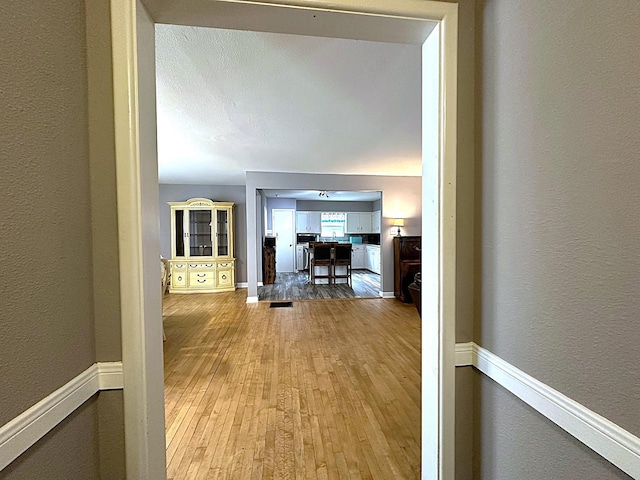 1325 W Chestnut St, Denison, TX 75020 - hallway featuring wood-type flooring and a textured wall
