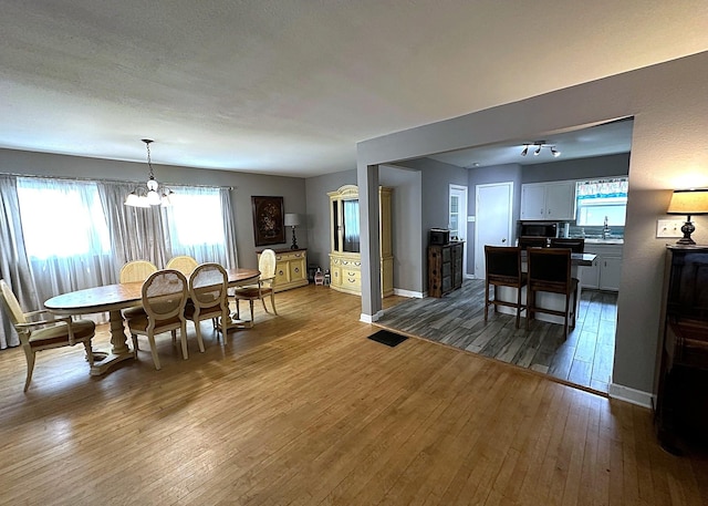 1325 W Chestnut St, Denison, TX 75020 - dining space featuring a chandelier and wood-type flooring