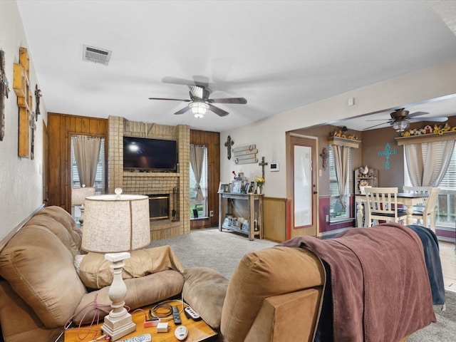 2012 Mobile Dr, Ennis, TX 75119 - living room featuring a ceiling fan, carpet, wooden walls, and a brick fireplace
