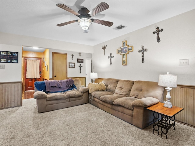 2012 Mobile Dr, Ennis, TX 75119 - living room featuring carpet, wainscoting, wooden walls, ceiling fan, and radiator heating unit