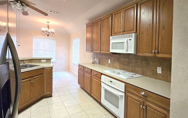 4012 Glenwyck Dr E, North Richland Hills, TX 76180 - kitchen featuring white appliances, light tile patterned floors, tasteful backsplash, ceiling fan, and brown cabinetry