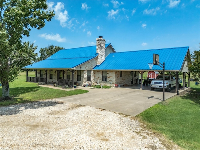 239 Valek Rd, Ennis, TX 75119 - rear view of property featuring concrete driveway, a chimney, a lawn, stone siding, and a metal roof