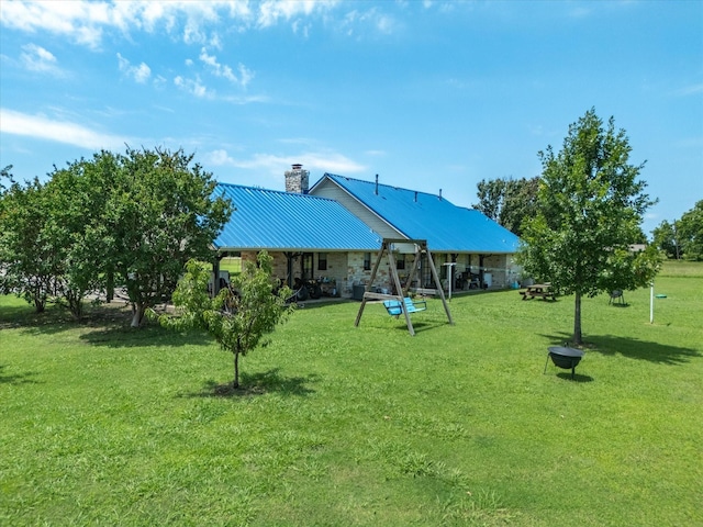 239 Valek Rd, Ennis, TX 75119 - rear view of property with a chimney, a yard, and a metal roof