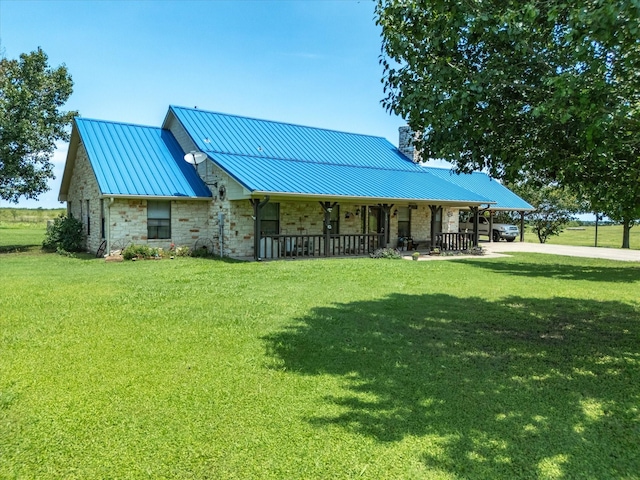 239 Valek Rd, Ennis, TX 75119 - view of front of home featuring stone siding, a porch, a front lawn, and a metal roof