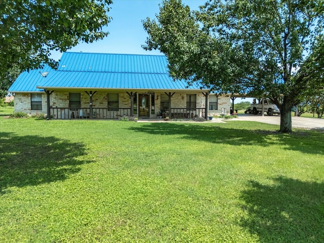 239 Valek Rd, Ennis, TX 75119 - view of front facade with stone siding, a porch, a front lawn, and a metal roof