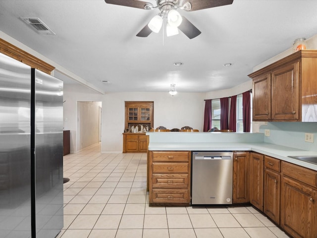 239 Valek Rd, Ennis, TX 75119 - kitchen with appliances with stainless steel finishes, light tile patterned floors, a peninsula, light countertops, and ceiling fan