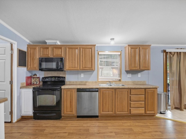 403 SE County Road 3048c, Corsicana, TX 75109 - kitchen featuring black appliances, crown molding, light countertops, and light wood finished floors