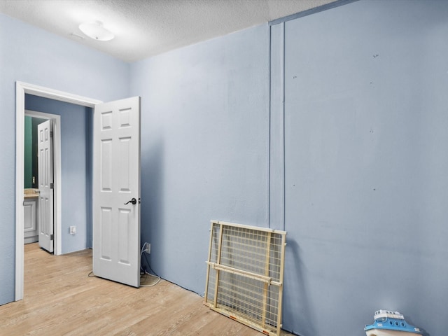 403 SE County Road 3048c, Corsicana, TX 75109 - unfurnished bedroom featuring light wood-type flooring and a textured ceiling