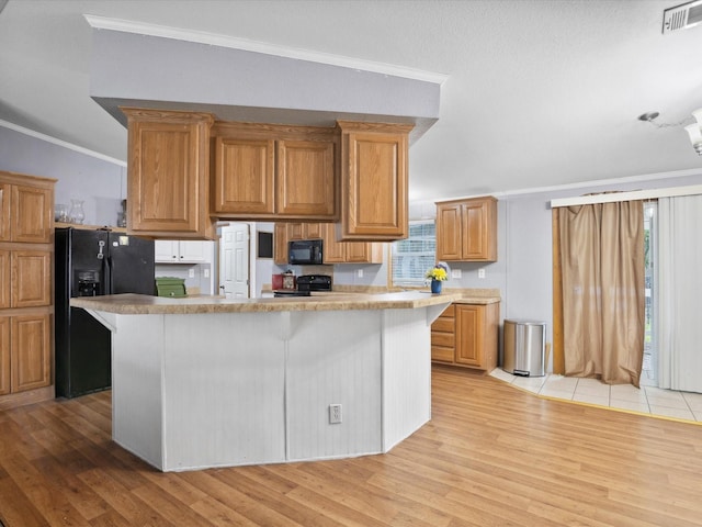 403 SE County Road 3048c, Corsicana, TX 75109 - kitchen featuring black appliances, crown molding, light wood-type flooring, a center island, and light countertops