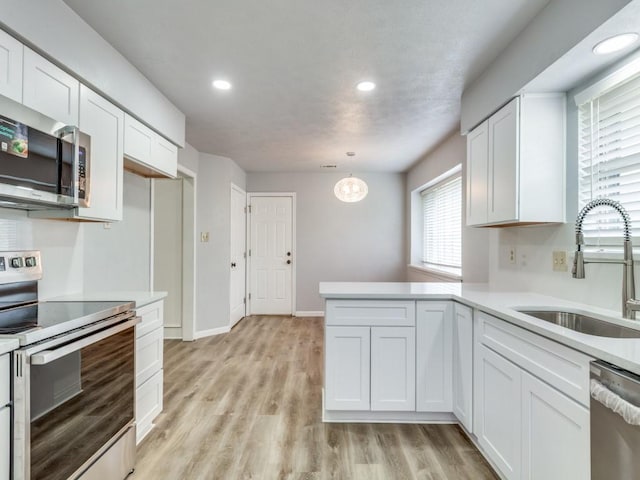 810 Serenade Ln, Richardson, TX 75081 - kitchen featuring stainless steel appliances, white cabinetry, light countertops, recessed lighting, and a peninsula