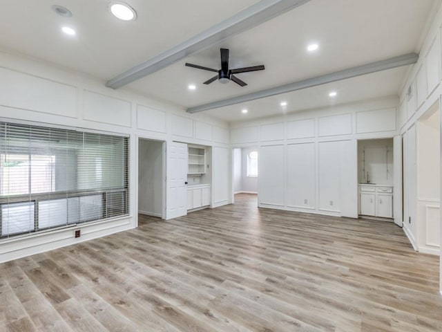 810 Serenade Ln, Richardson, TX 75081 - unfurnished living room featuring a decorative wall, beam ceiling, ceiling fan, and light wood-style flooring