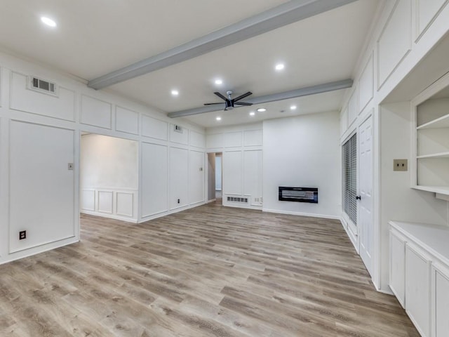 810 Serenade Ln, Richardson, TX 75081 - unfurnished living room featuring a decorative wall, ceiling fan, beamed ceiling, light wood-style flooring, and a glass covered fireplace
