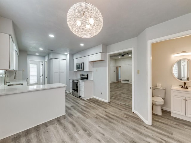 810 Serenade Ln, Richardson, TX 75081 - kitchen with appliances with stainless steel finishes, light wood-type flooring, a chandelier, light countertops, and white cabinets