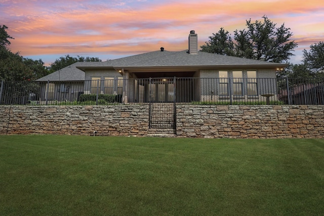 8502 Linden Ct, Granbury, TX 76049 - back of house at dusk with a chimney, a shingled roof, and brick siding