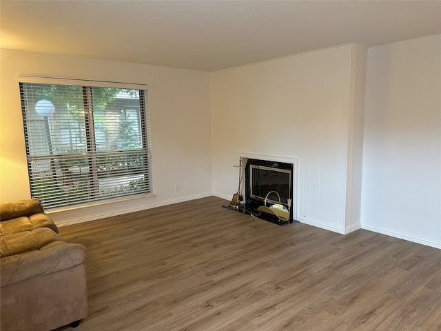 6036 Birchbrook Dr Unit 127, Dallas, TX 75206 - unfurnished living room featuring wood finished floors and a glass covered fireplace