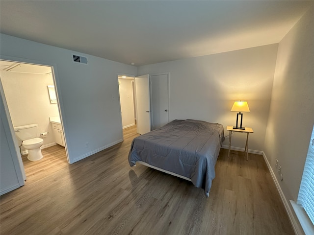 6036 Birchbrook Dr Unit 127, Dallas, TX 75206 - bedroom featuring wood finished floors and connected bathroom