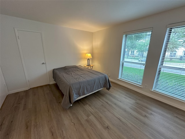 6036 Birchbrook Dr Unit 127, Dallas, TX 75206 - bedroom featuring wood finished floors and baseboards