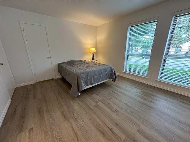 6036 Birchbrook Dr Unit 127, Dallas, TX 75206 - bedroom featuring wood finished floors and baseboards