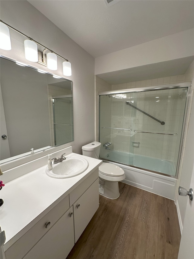6036 Birchbrook Dr Unit 127, Dallas, TX 75206 - full bathroom featuring wood finished floors, vanity, and bath / shower combo with glass door