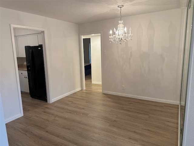 6036 Birchbrook Dr Unit 127, Dallas, TX 75206 - unfurnished dining area with wood finished floors and a chandelier