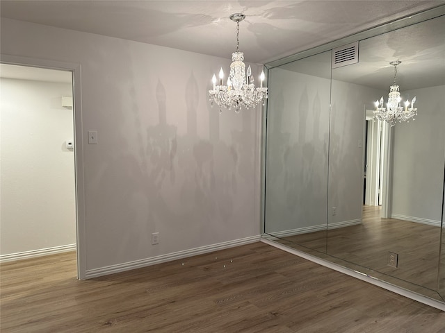 6036 Birchbrook Dr Unit 127, Dallas, TX 75206 - unfurnished dining area featuring a chandelier and wood finished floors