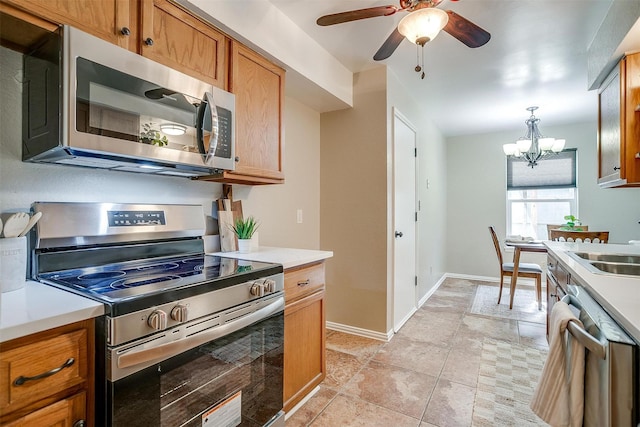 221 Sierra Dr, Joshua, TX 76058 - kitchen with stainless steel appliances, ceiling fan, a chandelier, light countertops, and brown cabinets