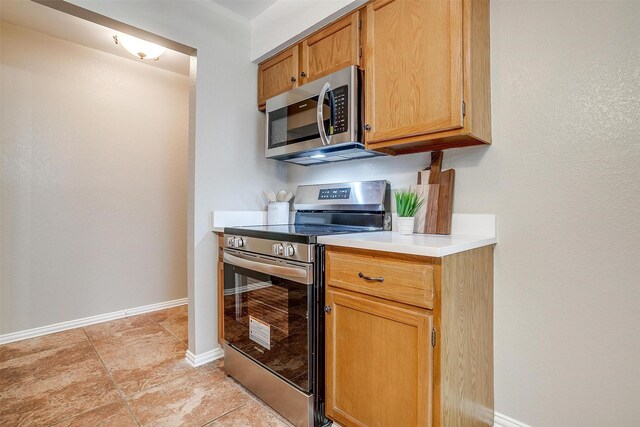 221 Sierra Dr, Joshua, TX 76058 - kitchen with stainless steel appliances, light countertops, and light tile patterned floors