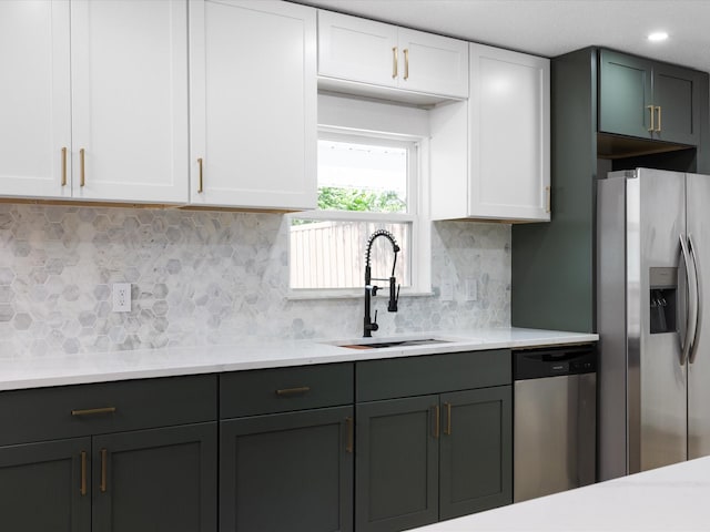 1910 Durham St, Irving, TX 75062 - kitchen with appliances with stainless steel finishes, light countertops, white cabinetry, and tasteful backsplash