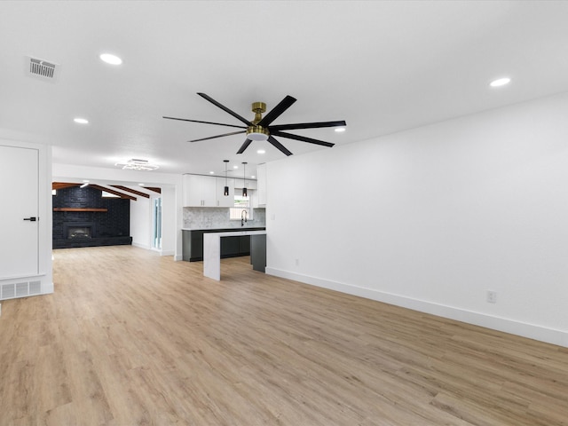 1910 Durham St, Irving, TX 75062 - unfurnished living room with ceiling fan, light wood-style flooring, recessed lighting, and a fireplace