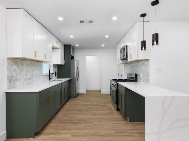 1910 Durham St, Irving, TX 75062 - kitchen featuring appliances with stainless steel finishes, white cabinetry, light wood-type flooring, backsplash, and recessed lighting