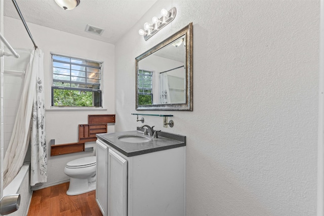 504 Cozby St N, Benbrook, TX 76126 - full bathroom featuring vanity, wood finished floors, a textured wall, shower / tub combo with curtain, and a textured ceiling