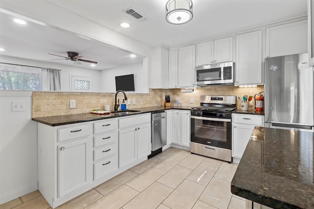 717 Thersa Dr, River Oaks, TX 76114 - kitchen featuring appliances with stainless steel finishes, tasteful backsplash, white cabinetry, dark stone counters, and ceiling fan