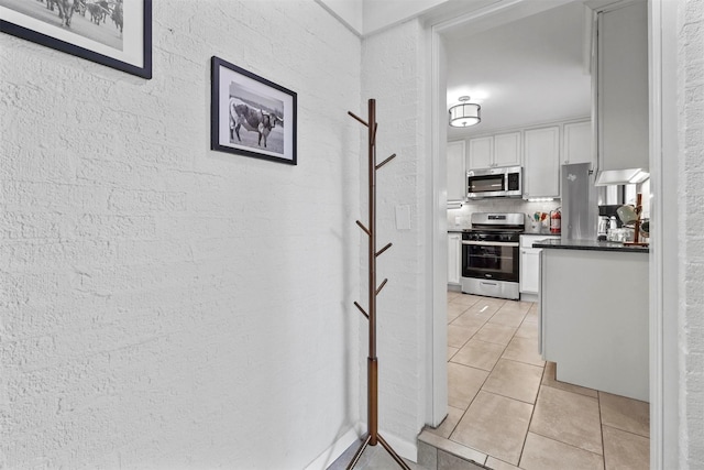 717 Thersa Dr, River Oaks, TX 76114 - hall with light tile patterned floors and a textured wall