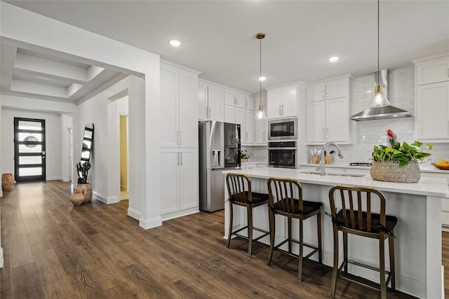 1430 Shaker Hills Rd, Gunter, TX 75058 - kitchen with appliances with stainless steel finishes, wall chimney range hood, light countertops, a center island with sink, and decorative backsplash