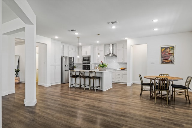 1430 Shaker Hills Rd, Gunter, TX 75058 - kitchen with appliances with stainless steel finishes, wall chimney exhaust hood, a breakfast bar area, white cabinets, and backsplash