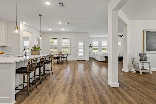 1430 Shaker Hills Rd, Gunter, TX 75058 - kitchen with light countertops, wood finished floors, white cabinets, recessed lighting, and a kitchen bar