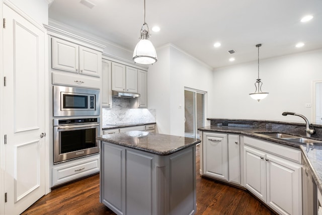 5913 Kensington Dr, Plano, TX 75093 - kitchen with stainless steel appliances, ornamental molding, recessed lighting, dark wood-style floors, and backsplash
