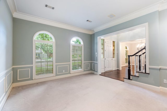5913 Kensington Dr, Plano, TX 75093 - carpeted empty room with crown molding, stairs, wainscoting, a chandelier, and a decorative wall