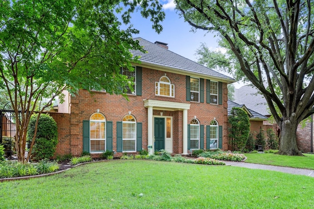 5913 Kensington Dr, Plano, TX 75093 - georgian-style home featuring brick siding, a chimney, and a front yard