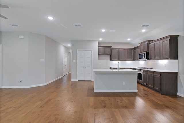 5524 Santa Elena Ct, Fort Worth, TX 76126 - kitchen with stainless steel appliances, light countertops, a center island with sink, wood finished floors, and dark brown cabinets