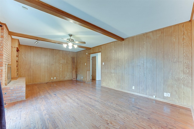 410 Ovilla Rd, Waxahachie, TX 75167 - unfurnished living room with beamed ceiling, wood finished floors, ceiling fan, and wooden walls