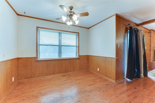 410 Ovilla Rd, Waxahachie, TX 75167 - empty room featuring crown molding, a wainscoted wall, a ceiling fan, light wood finished floors, and wood walls