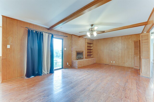 410 Ovilla Rd, Waxahachie, TX 75167 - unfurnished living room featuring wood walls, beamed ceiling, ceiling fan, wood finished floors, and a fireplace