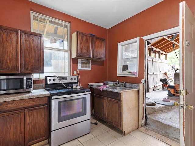 2232 E Kiest Blvd, Dallas, TX 75216 - kitchen featuring appliances with stainless steel finishes, light tile patterned flooring, and a wall mounted AC
