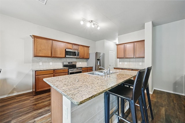 1209 Jasper Xing, Princeton, TX 75407 - kitchen featuring appliances with stainless steel finishes, dark wood-style flooring, tasteful backsplash, and brown cabinets