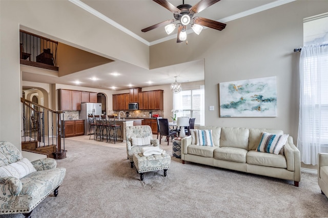 3820 Buchanan St, Mckinney, TX 75071 - living area featuring light colored carpet, a towering ceiling, crown molding, ceiling fan, and arched walkways