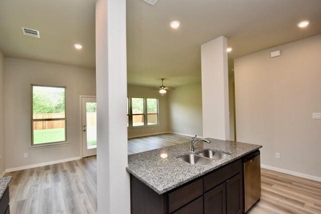 2609 Donella Dr, Denton, TX 76207 - kitchen featuring light wood-style floors, dishwasher, light stone counters, open floor plan, and dark brown cabinets