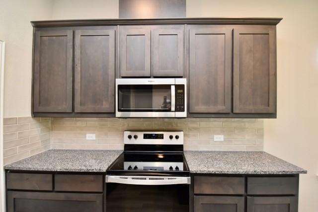 2609 Donella Dr, Denton, TX 76207 - kitchen featuring stainless steel appliances, backsplash, and dark brown cabinets