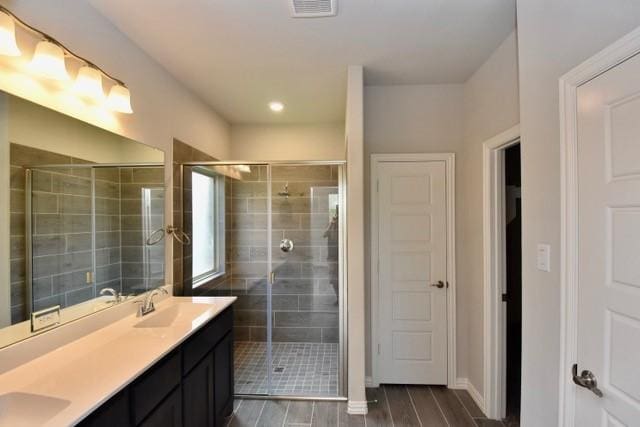 2609 Donella Dr, Denton, TX 76207 - bathroom with a stall shower, double vanity, and wood finished floors